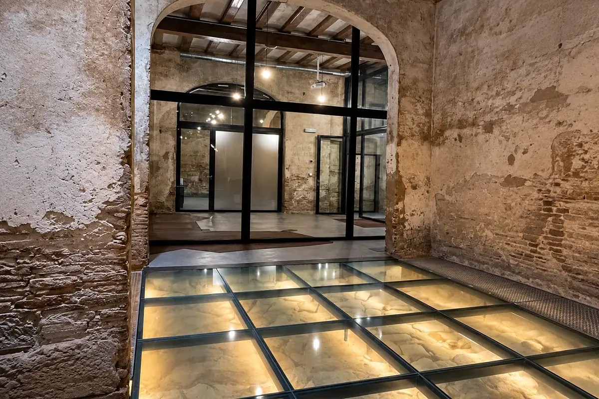 Cerramiento de acero y vidrio con suelo de vidrio iluminado